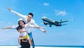 Asian happy family have fun on the beach watching the landing planes. Traveling on an airplane for leisure