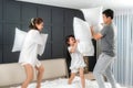 Asian happy family having funny pillow fight on white bed in bedroom for free time with father, mother and daughters feeling happy Royalty Free Stock Photo