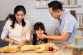 Asian happy family, Mother cook food for dinner in kitchen at house. Loving Father and little girl have fun spend time together Royalty Free Stock Photo