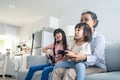 Asian happy family stay home, grandmother play game with little girl. Loving senior elder older woman play video games in front of Royalty Free Stock Photo