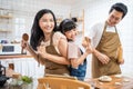 Asian happy family stay home in kitchen bake bakery and dance together. Fatherand mother spend free time with young little girl