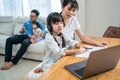 Asian happy family stay home, parents spend time with young little kid daughter in living room together. Loving mother teach and Royalty Free Stock Photo