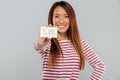 Asian happy lady standing isolated holding credit card. Royalty Free Stock Photo