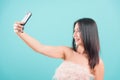 Woman standing smiling her take a selfie video-call on front camera smartphone Royalty Free Stock Photo