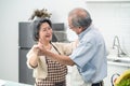 Asian happy Senior elderly couple standing in kitchen at house enjoy retirement life and dancing together. Loving Older Royalty Free Stock Photo