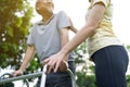 Asian happy Senior retired grandfather enjoy outdoor at green park. Attractive girl daughter help elderly handicaps father walk Royalty Free Stock Photo