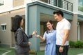 Asian happy smile young couple take keys new big house from real estate agent or realtor in front of their house after signing Royalty Free Stock Photo