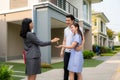 Asian happy smile young couple take keys new big house from real estate agent or realtor in front of their house after signing Royalty Free Stock Photo