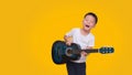 Asian happy smiling boy having fun playing guitar isolated on colored background, Music for kids and toddlers concept Royalty Free Stock Photo