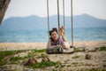 Asian happy woman on a swing on a tropical beach Royalty Free Stock Photo