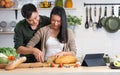 Asian happy young adult couple lover helping together for cooking in cozy home kitchen in morning, preparing meal, making salad, Royalty Free Stock Photo