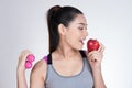 Asian healthy athletic sporty girl with red apple and dumbbell a Royalty Free Stock Photo