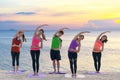 Asian healthy people lifestyle group exercising vital meditate and practicing yoga pose and training class on beach.