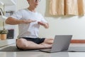 Asian healthy trainer man using laptop for teaching online healthcare yoga and meditation course at home. Man teaching breathing Royalty Free Stock Photo
