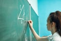 asian high school girl solves geometry on the blackboard