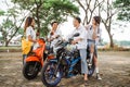 Asian high school students chatting on a motorbike