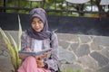 asian hijab muslim woman writing her diary in park Royalty Free Stock Photo