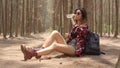 Asian hiker woman trekking in forest. Young happy backpack girl sitting rest drink water from bottle after walking travel nature Royalty Free Stock Photo