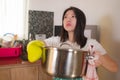 Asian home cook girl lifestyle portrait . Young happy and beautiful Korean woman in kitchen apron and glove holding cooking pot Royalty Free Stock Photo