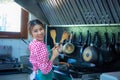 Asian home cook woman holding spatula with both hands cooking in the kitchen and looking to the camera, Healthy Food. Royalty Free Stock Photo