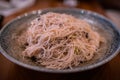 Fried vermicelli rice noodles, bee hoon goreng on a blue Japanese plate.