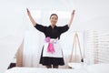 Asian housekeeper in special uniform covers bed. Royalty Free Stock Photo