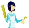 Asian housemaid holding spray bottle and duster.