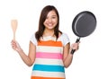 Asian Housewife hold up with frying pan and wooden ladle Royalty Free Stock Photo