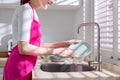 Asian housewife wash dishes Royalty Free Stock Photo