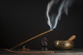 Asian incense stick in stick holder burning with smoke on black background Royalty Free Stock Photo