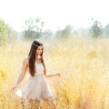 Asian indian woman walking in golden dried field Royalty Free Stock Photo