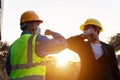 Asian industry construction site worker and foreman wearing hygiene face mask elbow bump greeting adaptation to prevent