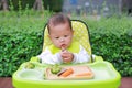 Asian infant baby boy eating by Baby Led Weaning BLW. Finger foods concept