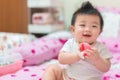 Asian Infant girl biting teether, baby growing first tooth Royalty Free Stock Photo