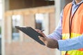 Asian inspector checking structure of new property and taking note in the clipboard for review and fix the house before sell. Royalty Free Stock Photo