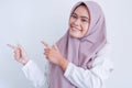 Asian Islam Muslim woman wearing headscarf is pointing finger to blank copy space smile face area. Indonesian woman. Religion Royalty Free Stock Photo