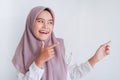 Asian Islam Muslim woman wearing headscarf is pointing finger to blank copy space smile face area. Indonesian woman. Religion Royalty Free Stock Photo