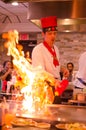 Hibachi restaurant chef preparing meal and entertaining guests