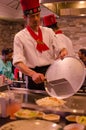 Hibachi restaurant chef preparing meal and entertaining guests
