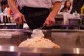 Hibachi restaurant chef preparing meal and entertaining guests