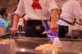 Hibachi restaurant chef preparing meal and entertaining guests