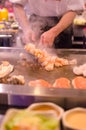 Hibachi restaurant chef preparing meal and entertaining guests