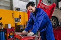Asian Japanese male mechanic worker portrait in auto service workshop car maintenance center replace fix auto engine part Royalty Free Stock Photo