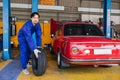 Asian Japanese male mechanic worker portrait in auto service workshop car tyre maintenance center replace fix auto part Royalty Free Stock Photo