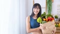 Asian Japanese woman holding shopping bag from supermarket full of organics vegetables and fruits for healthy food and vegetarian Royalty Free Stock Photo