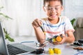 Asian kid boy assembling the Arduino robot car homework project at home