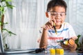 Asian kid boy assembling the Arduino robot car homework project at home