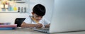 Asian Kid Boy Focused on Homework and Learning Alone in Room at Home, Serious Asian Kid Concentrating on Homework, Studying and Royalty Free Stock Photo