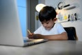 Asian Kid Boy Focused on Homework and Learning Alone in Room at Home, Serious Asian Kid Concentrating on Homework, Studying and Royalty Free Stock Photo