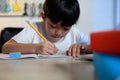 Asian Kid Boy Focused on Homework and Learning Alone in Room at Home, Serious Asian Kid Concentrating on Homework, Studying and Royalty Free Stock Photo